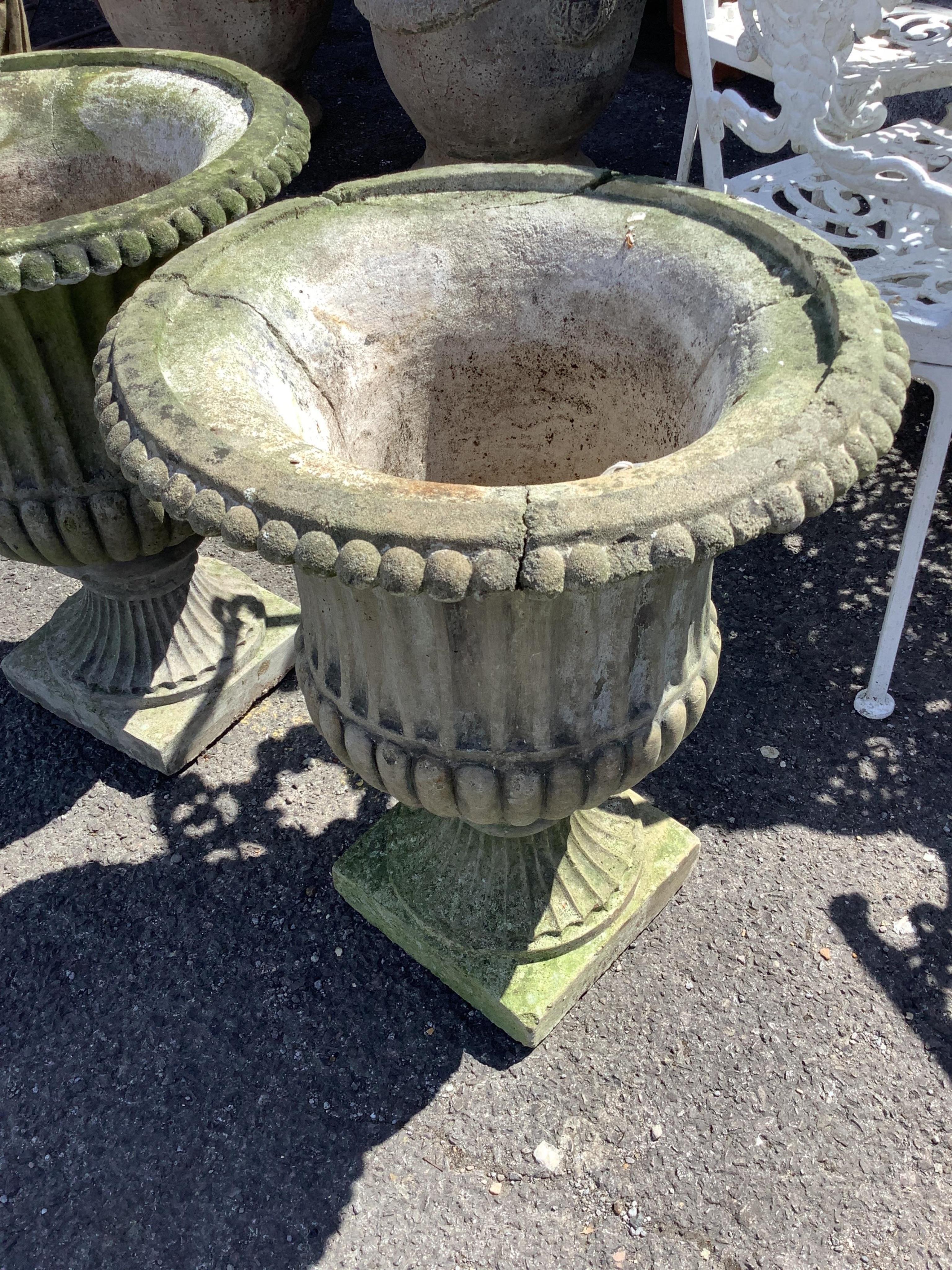 A pair of reconstituted stone campana garden urns on pedestal bases, diameter 46cm, height 58cm